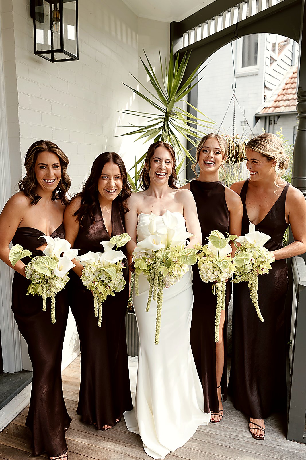 Bridesmaids in chocolate silk with white and green bouquets