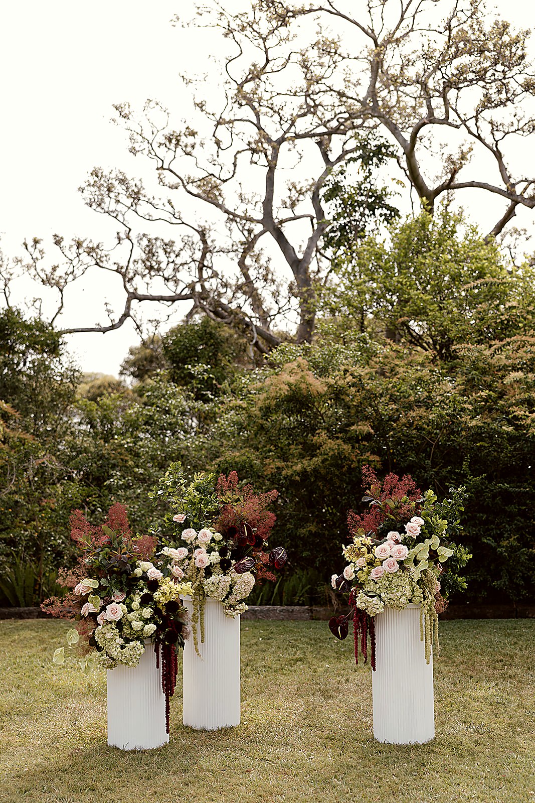 Garden ceremony — three white pedestals